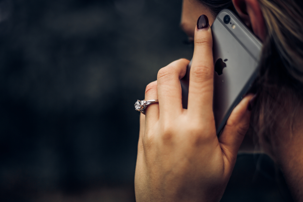 main avec bague en diamant et téléphone